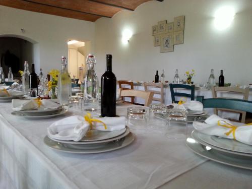 a table with white plates and wine bottles on it at Agriturismo Pretenzano in Volterra
