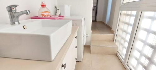 a white kitchen with a sink and a staircase at Sitrin apartment Leonardo Hotel Area Ashdod in Ashdod