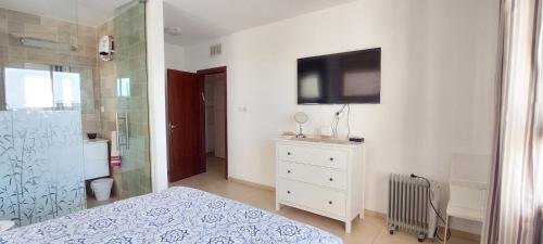 a bedroom with a shower and a television on the wall at Sitrin apartment Leonardo Hotel Area Ashdod in Ashdod