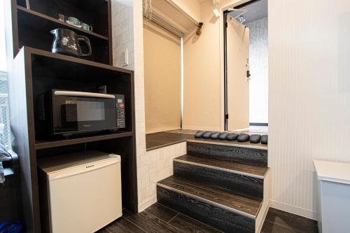 a bathroom with a walk in shower and a microwave at GRAND CAVE MOTOMACHI in Yokohama