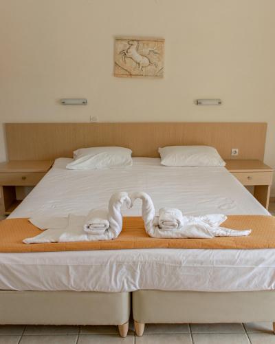 two towels in the shape of swans on a bed at Olympion Village in Kavos