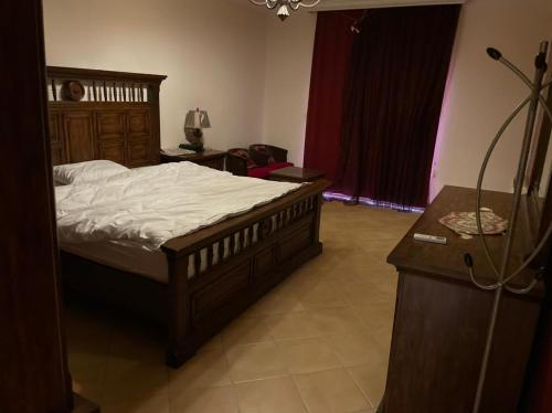 a bedroom with a bed and a dresser and a table at درة العروس - فيلا الحلم Dream 4u in Durat Alarous