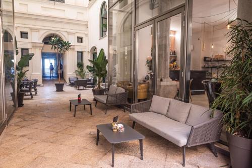 a lobby with a couch and tables in a building at Central Gallery Rooms- Palazzo D'Ali' Staiti XIX in Trapani