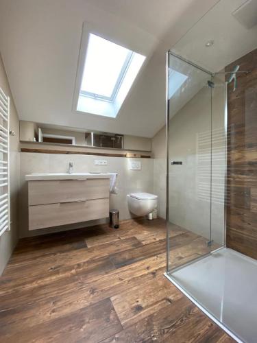 a bathroom with a sink and a toilet and a skylight at Ferienwohnung Panorama inkl. Chiemgaukarte in Ruhpolding