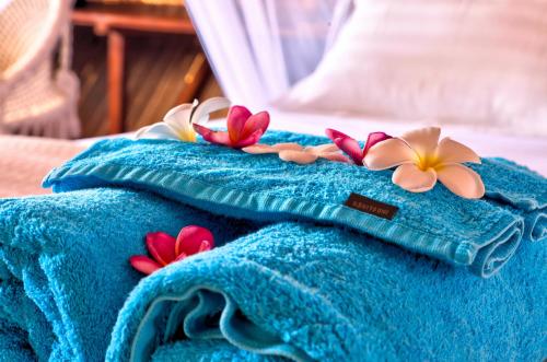 a blue towel with flowers on top of it at Loedi Bungalows Rote in Nembrala
