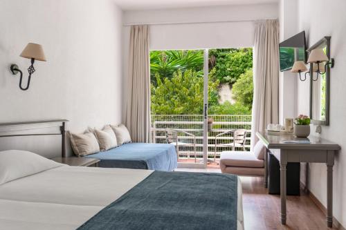 een hotelkamer met 2 bedden en een balkon bij Louis Ionian Sun in Agios Ioannis Peristerion