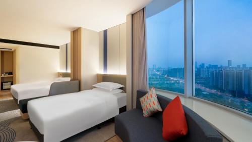 a hotel room with two beds and a large window at Holiday Inn Express Changsha Kaifu by IHG in Changsha