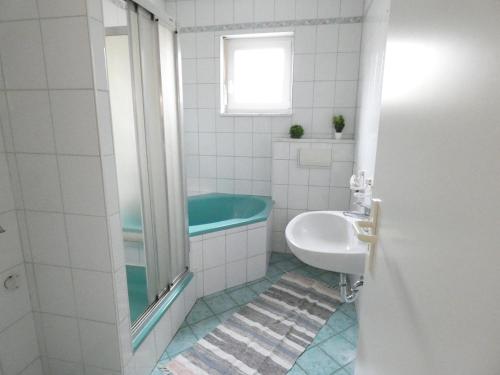 a bathroom with a bath tub and a sink at SUNNYHOME Monteurwohnungen und Apartments in Weiden in Moosbürg