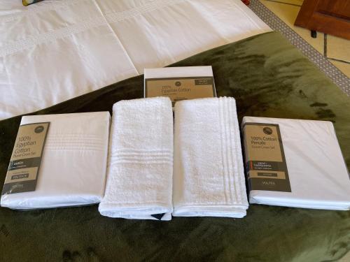 three white towels and two boxes on a bed at Walkersons Trout and Nature Haven in Dullstroom