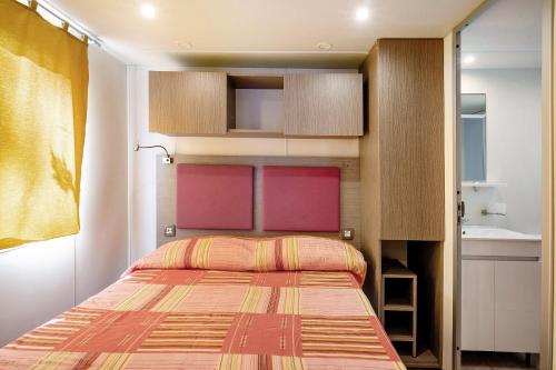 ein kleines Schlafzimmer mit einem Bett und einem Waschbecken in der Unterkunft Camping Grande Italia Vulcano 8 in Chioggia