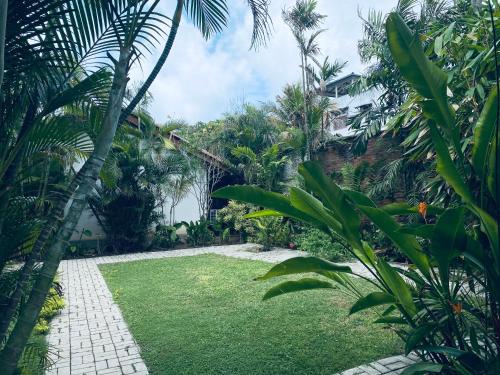 a garden with green grass and palm trees at Cottage Garden Bungalows in Mount Lavinia