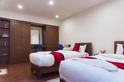 a bedroom with two beds and a closet at Sweet Inn in Bhaktapur