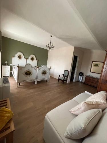 a bedroom with two white beds and a wooden floor at B&B Cascina Cortassa in Monteu Roero