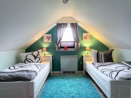 twee bedden in een kamer met groene muren en een raam bij Ferienhaus DolceVita in Walkenried