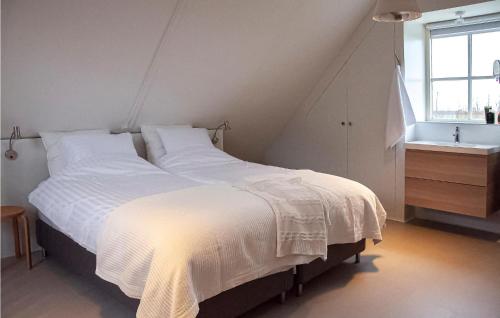 um quarto com uma grande cama branca e um lavatório em Lovely Home In Wijdenes With Wifi em Wijdenes