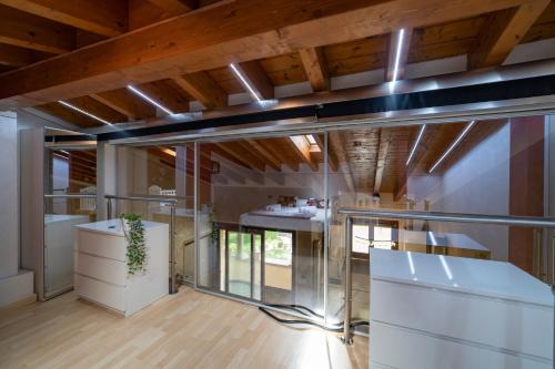 a kitchen with glass walls and wooden ceilings at DIAMOND SUITE in Sulzano