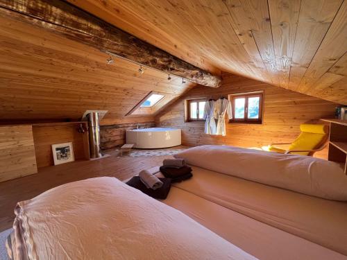 a room with two large beds in a wooden cabin at Chalet Biene - Swiss Alp Chalet with Sauna and Jacuzzi in Ulrichen
