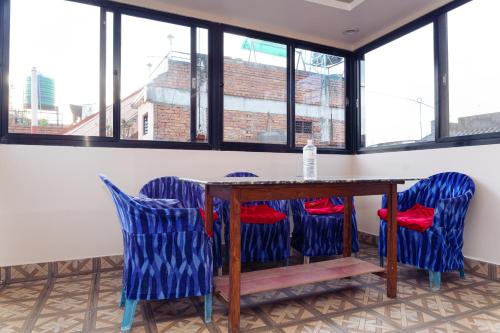 a dining room with a table and blue chairs at Sweet Inn in Bhaktapur