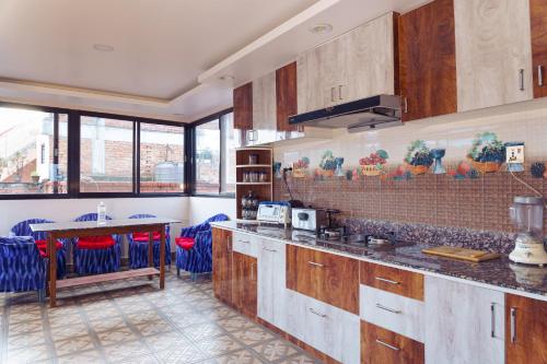 a kitchen with wooden cabinets and a table with chairs at Sweet Inn in Bhaktapur