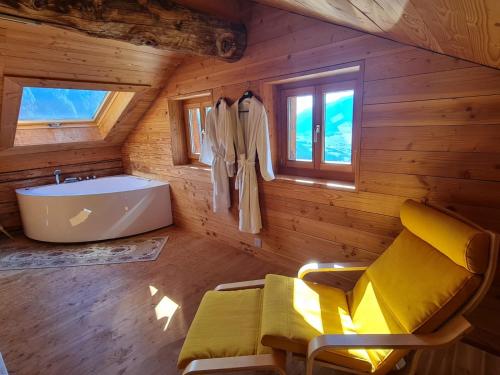 un bagno con vasca e lavandino in una cabina di Chalet Biene - Swiss Alp Chalet with Sauna and Jacuzzi a Ulrichen