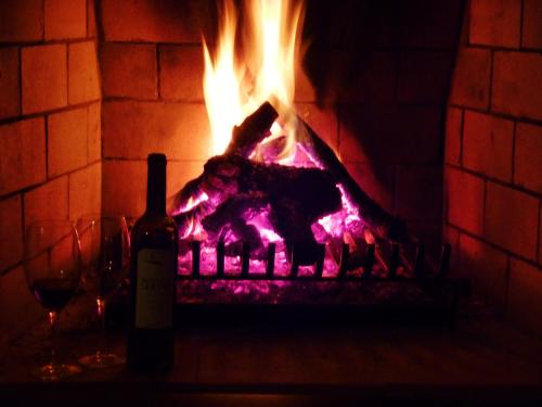 a bottle of wine next to a brick fireplace at Hotel Rural Monte da Provença in Elvas