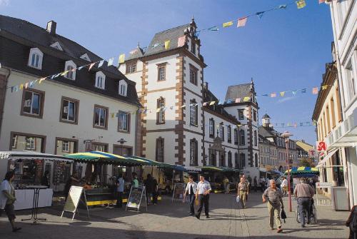 a group of people walking down a street with buildings at Ferienwohnung Grete in Merzig