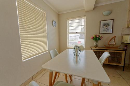 a dining room with a white table and chairs at Klein Sterretjie in Paternoster