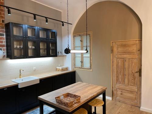 a kitchen with a wooden table and a sink at Apartamenty Żeglarska 25 in Toruń