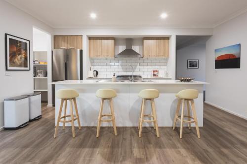a kitchen with a counter and stools in it at Sauna, King Beds, Tranquility Base Fun Large Home in Saint Leonards