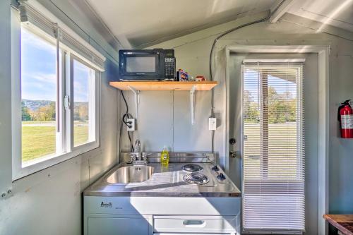 una pequeña cocina con fregadero y TV en Cozy Huntsville Cabin, Near ATV Trail Access!, en Huntsville