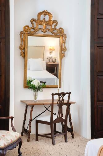a mirror on a wall above a table with a bed at Ca'n Puig de Sòller in Sóller