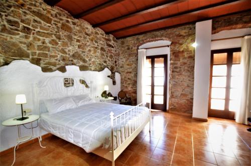 a bedroom with a bed and a stone wall at LUXURY HOUSE 8 PERSONS FRONT THE BEACH BLANES COSTA BRAVA in Blanes