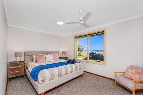 a bedroom with a bed and a window and a chair at Esplanade Escape Absolute Beachfront WIFI-NBN in Middleton