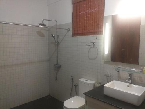 a bathroom with a shower and a toilet and a sink at De Mansion Hotels in Katugastota