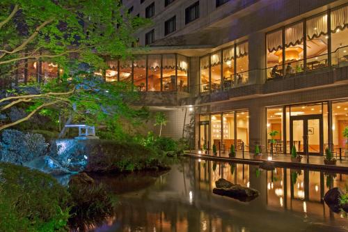 a building with a river in front of it at HOTEL MYSTAYS PREMIER Narita in Narita