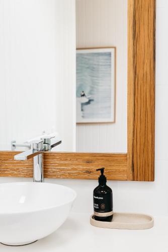 a bathroom sink with a soap dispenser next to a mirror at Anchor Geelong in Geelong