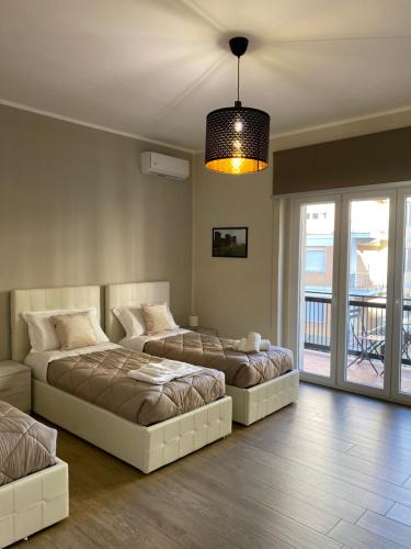 a bedroom with two beds and a light fixture at Morelli B&B in Rossano Stazione