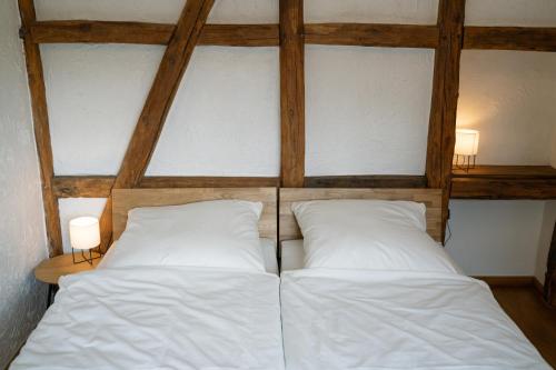 a bed with two white pillows in a room at Gemütliches Fachwerkhaus im Herzen Nideggens in Nideggen