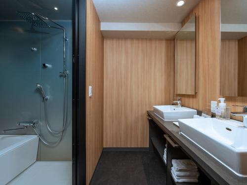 a bathroom with two sinks and a shower and a tub at MIMARU Tokyo Ikebukuro in Tokyo