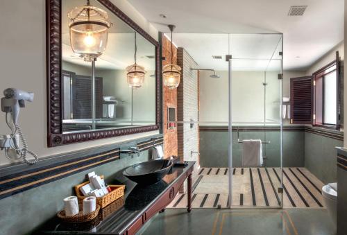 a bathroom with a sink and a mirror at Niraamaya Wellness Retreats Backwaters And Beyond Kumarakom in Kumarakom