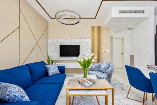 a living room with a blue couch and chairs at Moderna Luxury Apartments with HEATED pool in Tivat