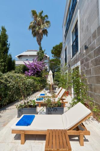 a row of tables and benches in front of a building at Moderna Luxury Apartments with HEATED pool in Tivat