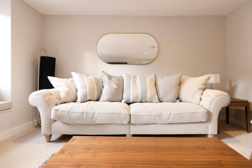 a white couch in a living room with a mirror at JOIVY Stylish flat near Perth Museum in Perth