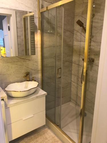 a bathroom with a glass shower with a sink at Apartment Warszawa in Warszawa