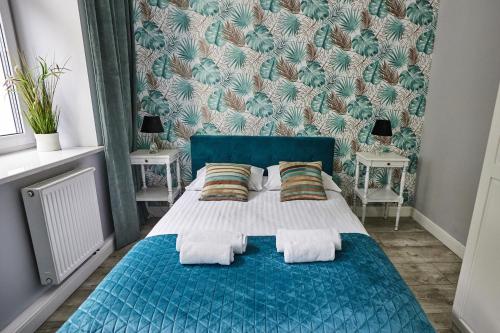 1 dormitorio con 1 cama azul y 2 almohadas en Niebieski Apartament DE LUX dla 4 osób Chorzów Katowice en Chorzów