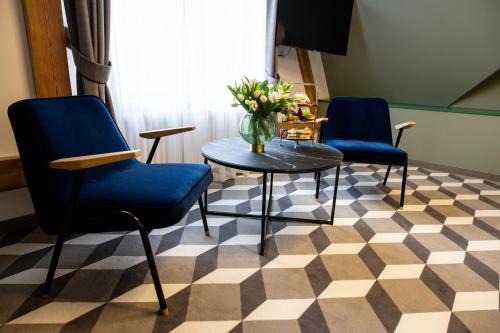a room with three chairs and a table with a vase of flowers at Villatoro in Zgorzelec