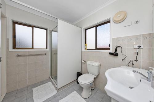 a white bathroom with a toilet and a sink at Tuggeranong Short Stay #11 in Tuggeranong