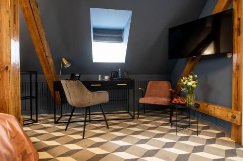a room with a desk and two chairs and a tv at Villatoro in Zgorzelec