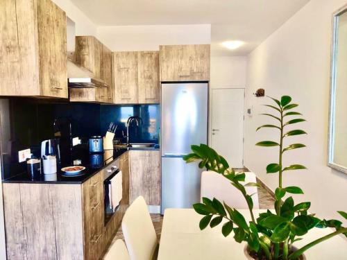 een keuken met houten kasten en een roestvrijstalen koelkast bij Oyster Flats - Seaside Apartment 7 in Żebbuġ