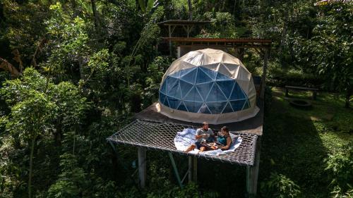 Bali Jungle Camping by Amerta Experience في تابانان: مجموعة من الناس يجلسون على طاولة في خيمة القبة